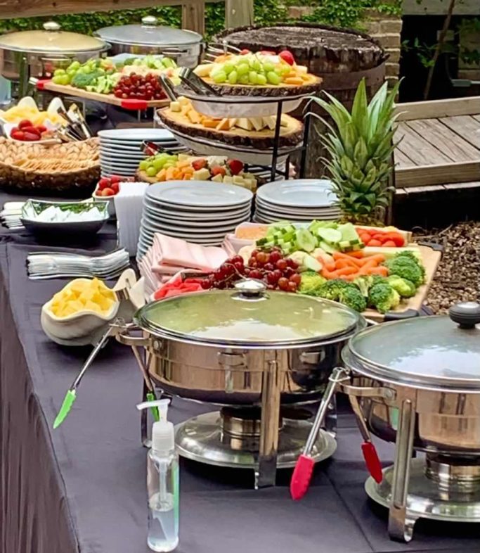 A buffet table with various salads, fruits, vegetables, and dishes ready for serving.