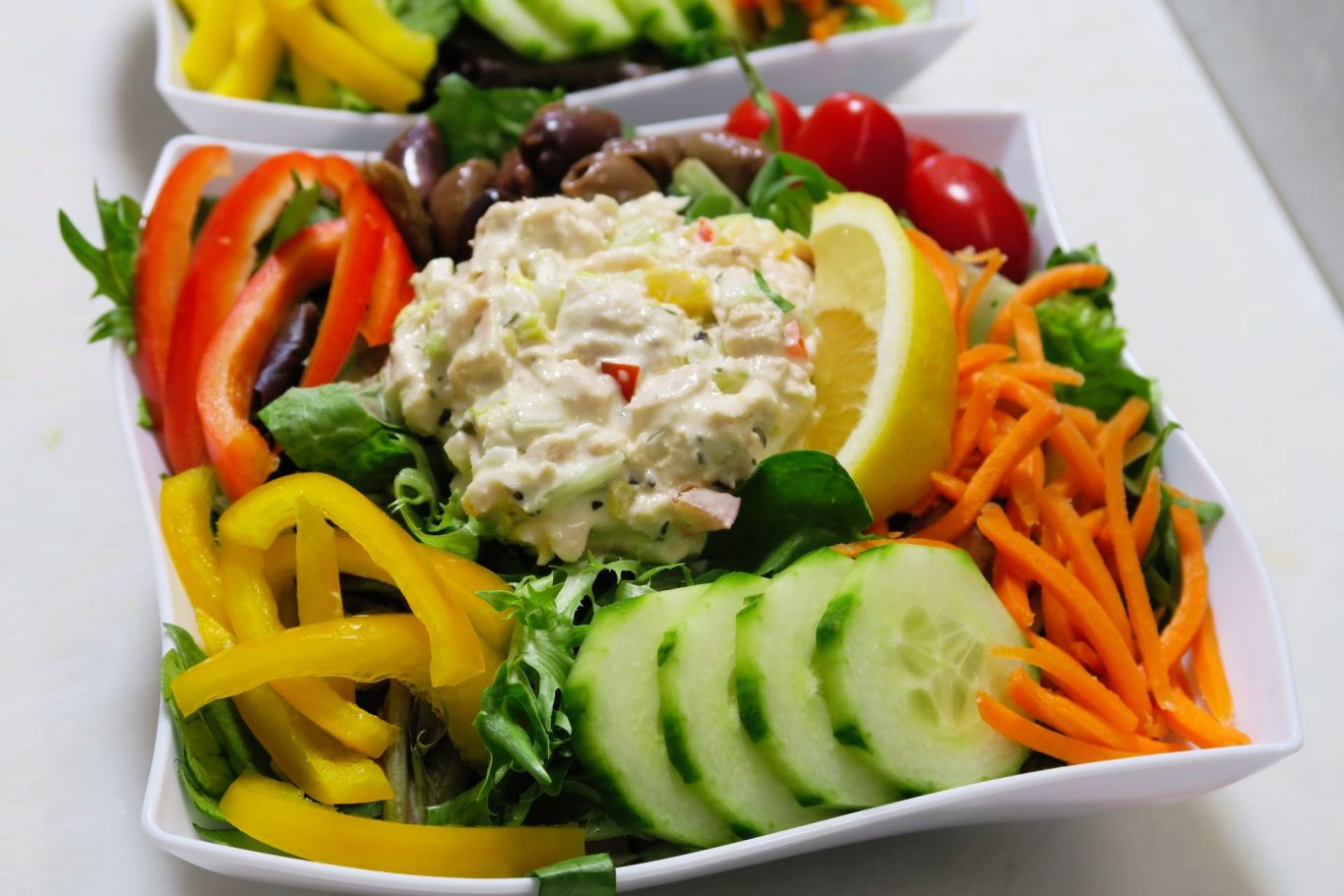 Lunch Salad Colorful salad with assorted vegetables, creamy dressing, and lemon slice on top.