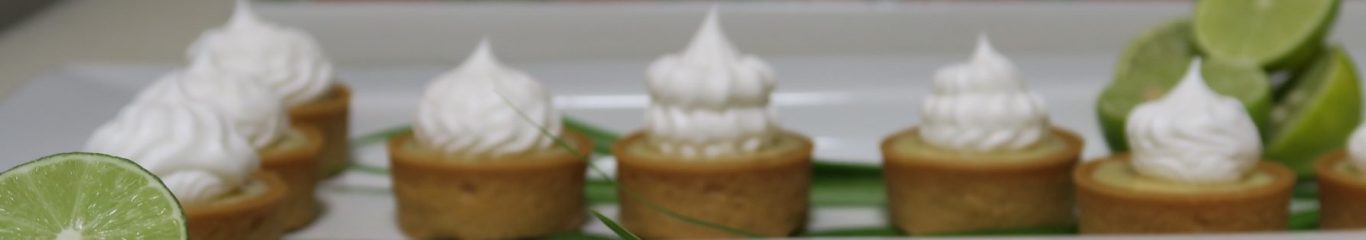 Mini tartlets topped with whipped cream and garnished with mint leaves.